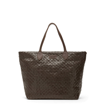 A large washable paper woven tote is shown. It has two long leather handles and a leather UASHMAMA logo label on the outside in between the handles. The bag shown is in a dark brown colour.