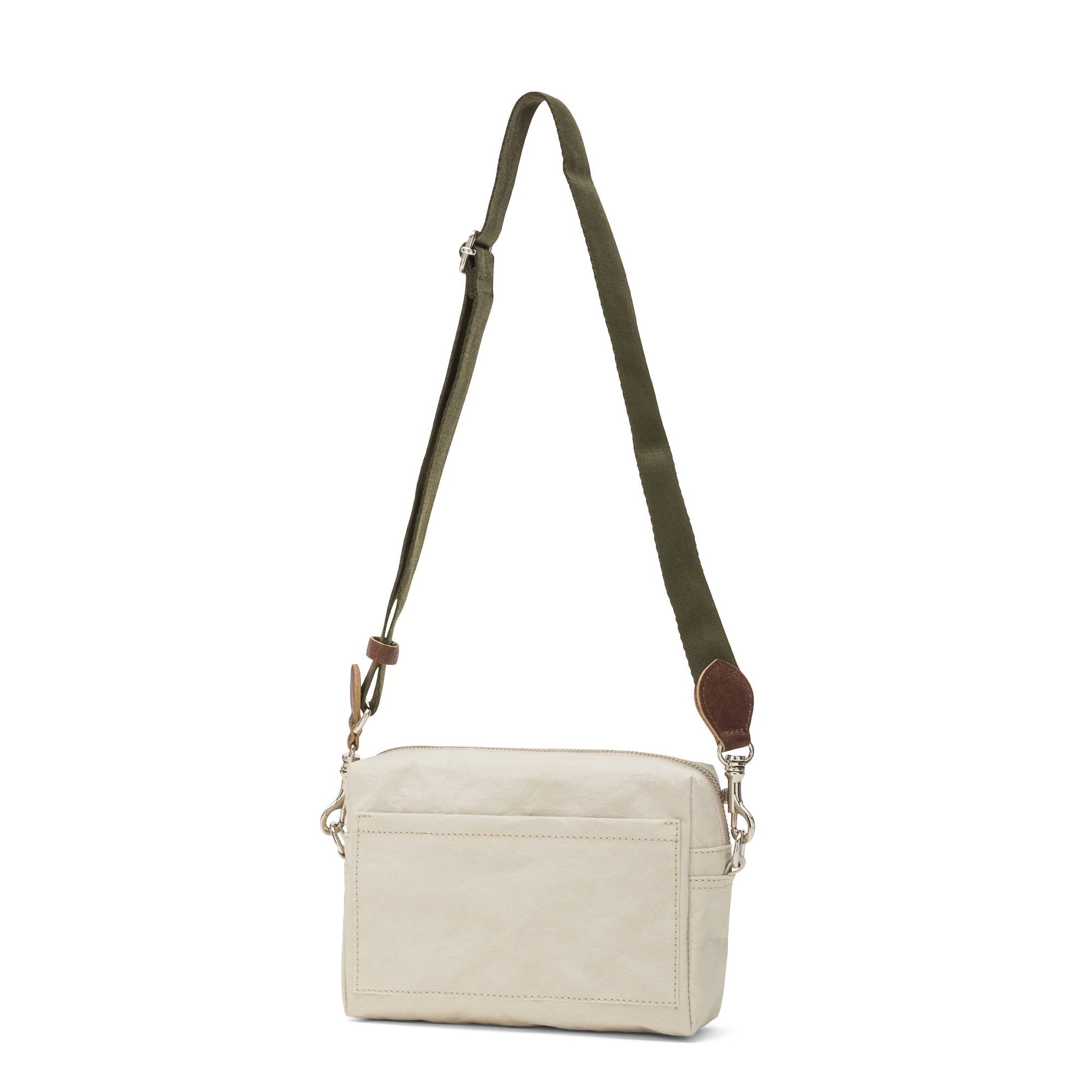 A rectangular washable paper handbag with an external side pocket is shown. The bag has a canvas strap, washable paper details and metal fastening clips to attach the straps to the bag. The bag closes by a zip. The bag shown is light cream with an olive strap.