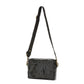 A rectangular washable paper handbag with an external side pocket is shown. The bag has a canvas strap, washable paper details and metal fastening clips to attach the straps to the bag. The bag closes by a zip. The bag shown is metallic black with a black strap.