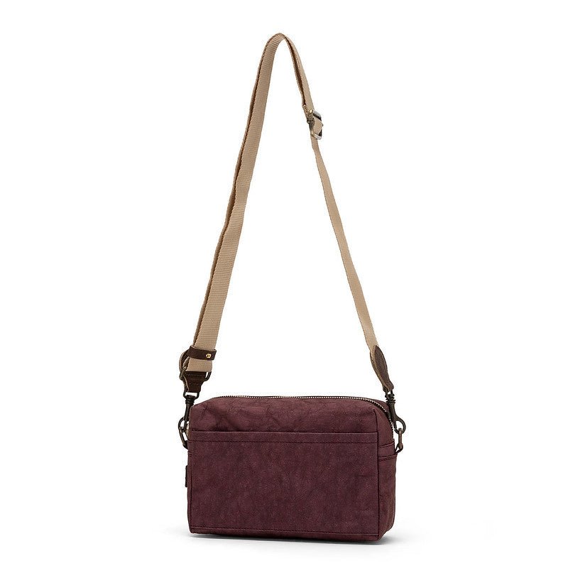A rectangular washable paper handbag with an external side pocket is shown. The bag has a canvas strap, washable paper details and metal fastening clips to attach the straps to the bag. The bag closes by a zip. The bag shown is dark purple with a wheat strap.