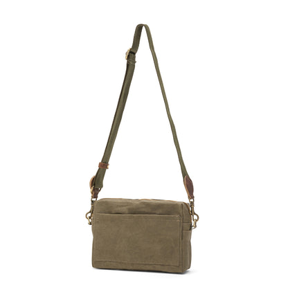 A rectangular washable paper handbag with an external side pocket is shown. The bag has a canvas strap, washable paper details and metal fastening clips to attach the straps to the bag. The bag closes by a zip. The bag shown is olive with an olive strap.