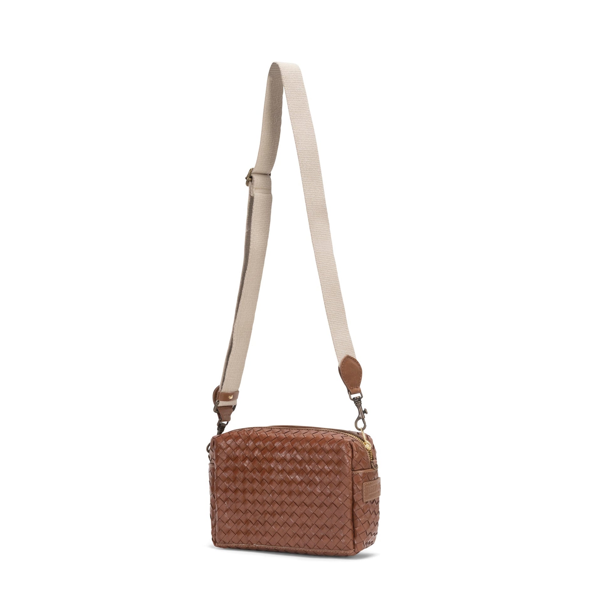 A small woven washable paper handbag is shown. The bag has a wide fabric shoulder strap. The bag is tan in colour and the strap is a light wheat colour.