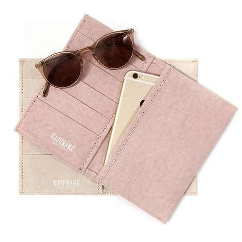 Two large wallets are shown lying open. On top of a pale beige coloured wallet, is a pale pink one. Sitting on top of the wallet side with 5 card slots, is a pair of sunglasses. Opposite these are one large pocket of the wallet which is shown with an iPhone inside.